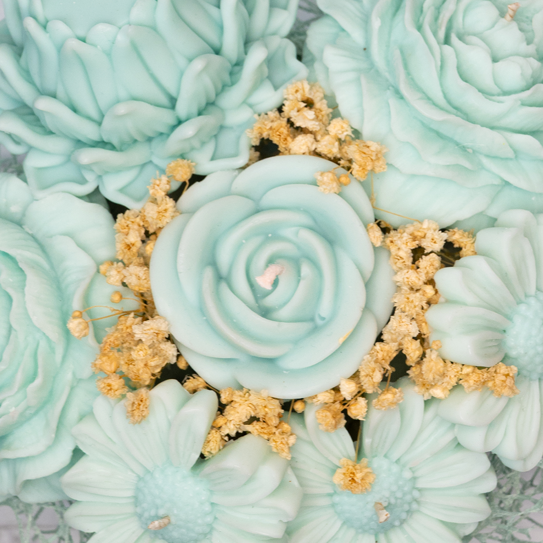 Close-up of mint green floral cookies with small yellow flowers on a textured surface