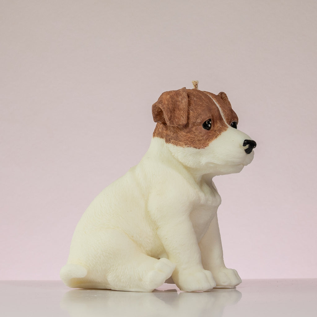 Luz Candles Au - A plush dog-shaped candle with a white body and brown ears, sitting on a light pink background.