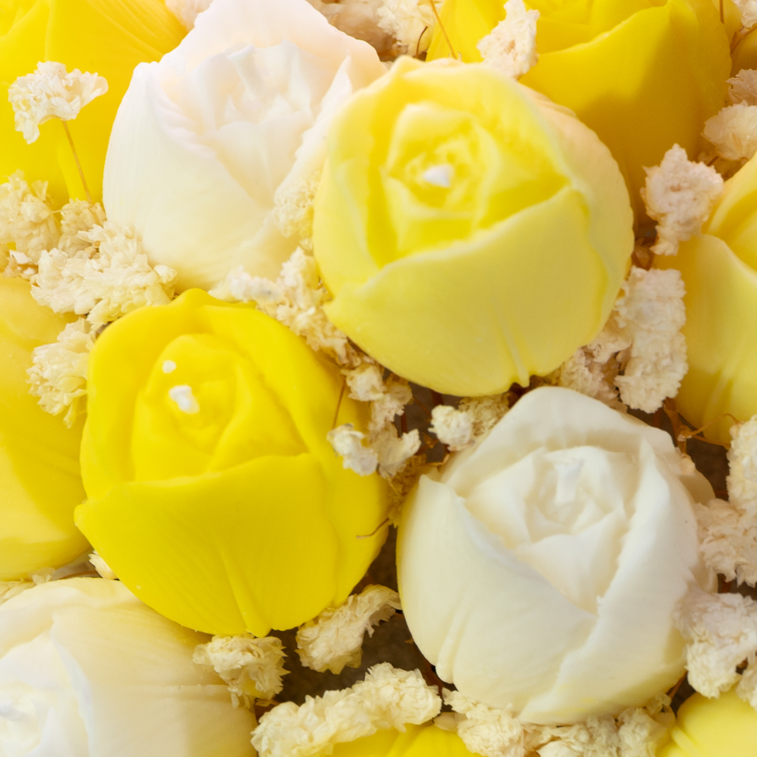 Close-up of yellow and white rose-shaped candies with small flowers.