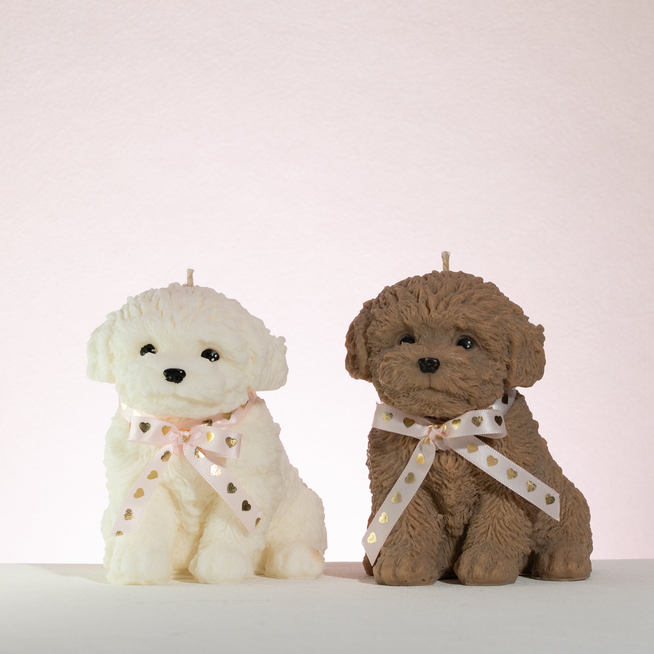 Two teddy bears, one white and one brown, sitting side by side on a light background.