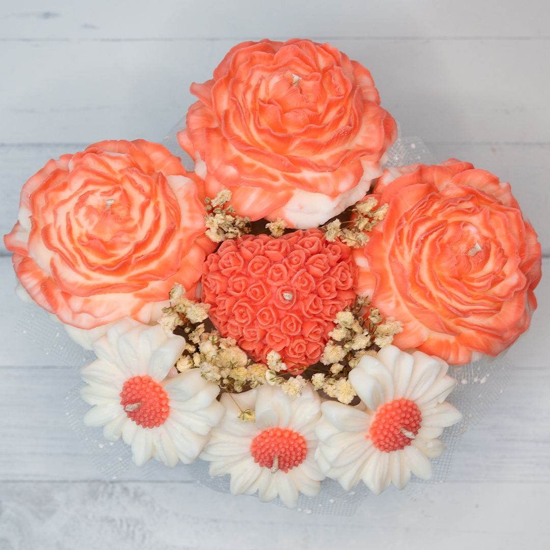 Decorative soap arrangement with coral and white flowers on a light gray background
