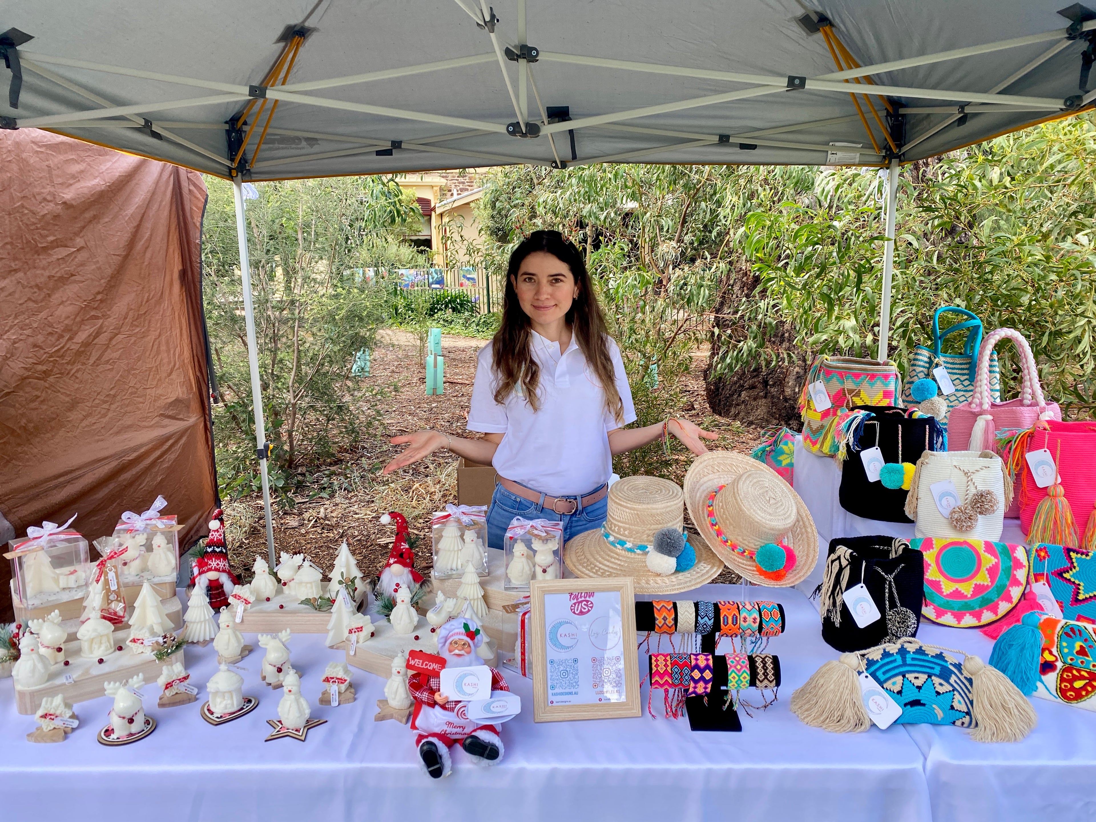 Luz from Luz Candles standing behind a table with various items at Fullarton market stall on 16th of December of 2023.